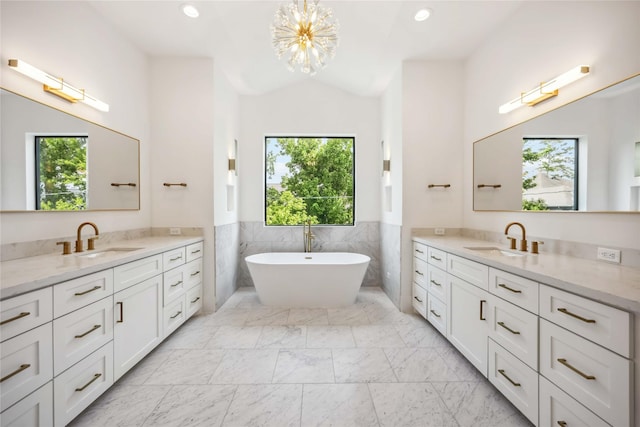 1913 Ebony Ln, Houston, TX 77018 - full bath with tile walls, two vanities, a chandelier, marble look tiles, and a soaking tub