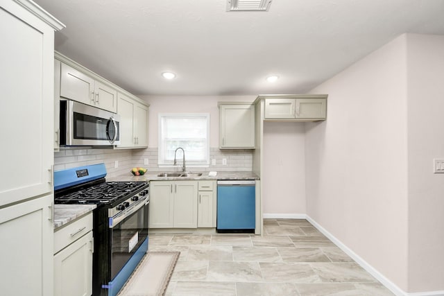 4918 Perry St, Houston, TX 77021 - kitchen featuring stainless steel appliances, a sink, decorative backsplash, baseboards, and light stone counters