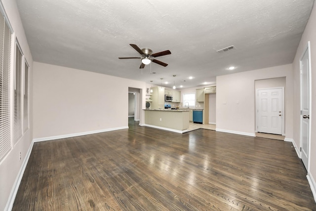 4918 Perry St, Houston, TX 77021 - unfurnished living room featuring ceiling fan, dark wood finished floors, recessed lighting, baseboards, and a textured ceiling