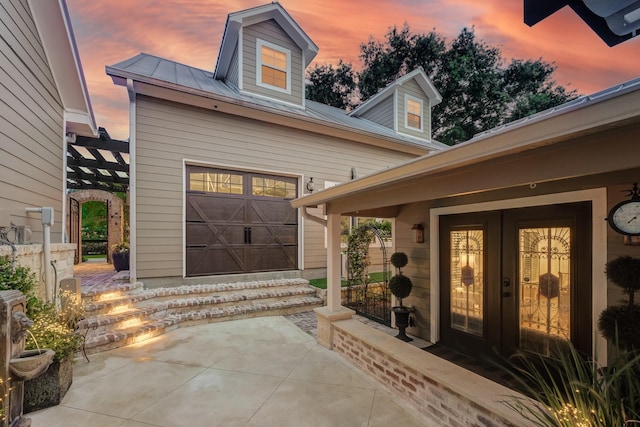 321 Marina Dr, Coldspring, TX 77331 - exterior entry at dusk featuring french doors and metal roof