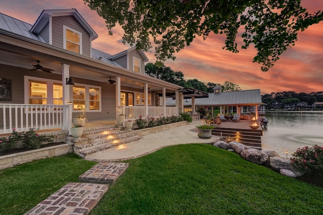 321 Marina Dr, Coldspring, TX 77331 - yard at dusk featuring ceiling fan, a yard, a patio, a boat dock, and a water view