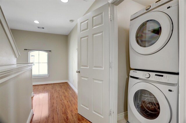 2617 Edgefield Lakes Dr, Houston, TX 77054 - washroom featuring stacked washing machine and dryer, baseboards, light wood-style flooring, and recessed lighting