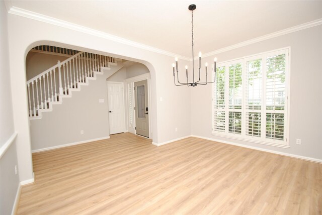 16611 Hope Farm Ln, Cypress, TX 77429 - empty room featuring a chandelier, light wood-style flooring, crown molding, baseboards, and arched walkways
