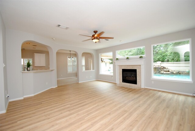 16611 Hope Farm Ln, Cypress, TX 77429 - unfurnished living room with a ceiling fan, baseboards, light wood finished floors, and healthy amount of natural light