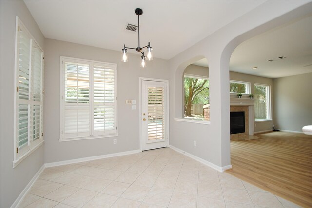 16611 Hope Farm Ln, Cypress, TX 77429 - entryway featuring baseboards, a chandelier, a fireplace, and arched walkways