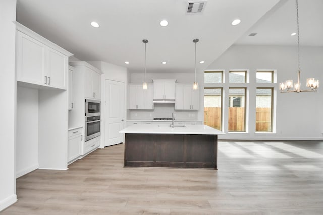 21111 Flowerhorn Dr, Cypress, TX 77433 - kitchen featuring light countertops, white cabinetry, a kitchen island with sink, light wood-style floors, and recessed lighting