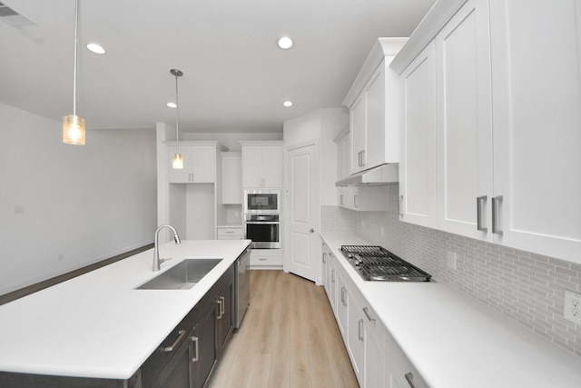 21111 Flowerhorn Dr, Cypress, TX 77433 - kitchen with stainless steel appliances, a sink, white cabinetry, light countertops, and light wood finished floors