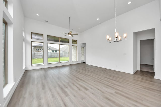 21111 Flowerhorn Dr, Cypress, TX 77433 - empty room with a chandelier, a ceiling fan, a high ceiling, recessed lighting, and wood finished floors