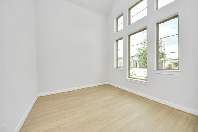 21114 Flowerhorn Dr, Cypress, TX 77433 - empty room with light wood-style floors, plenty of natural light, baseboards, and lofted ceiling