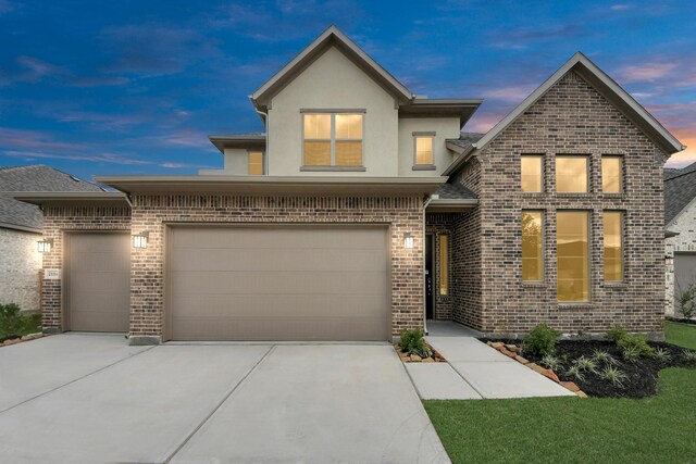 21114 Flowerhorn Dr, Cypress, TX 77433 - view of front of property featuring driveway, brick siding, stucco siding, and an attached garage