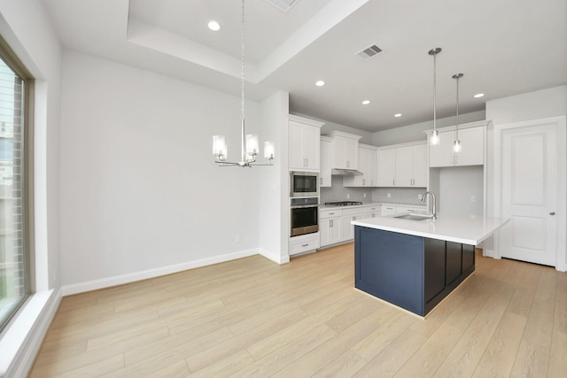 21114 Flowerhorn Dr, Cypress, TX 77433 - kitchen featuring appliances with stainless steel finishes, a sink, a chandelier, light wood finished floors, and backsplash