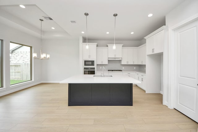 21114 Flowerhorn Dr, Cypress, TX 77433 - kitchen with stainless steel oven, black microwave, a sink, a chandelier, and light wood finished floors