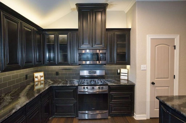 107 Brazos Ct, Richwood, TX 77531 - kitchen featuring appliances with stainless steel finishes, decorative backsplash, dark wood-style floors, dark stone counters, and vaulted ceiling