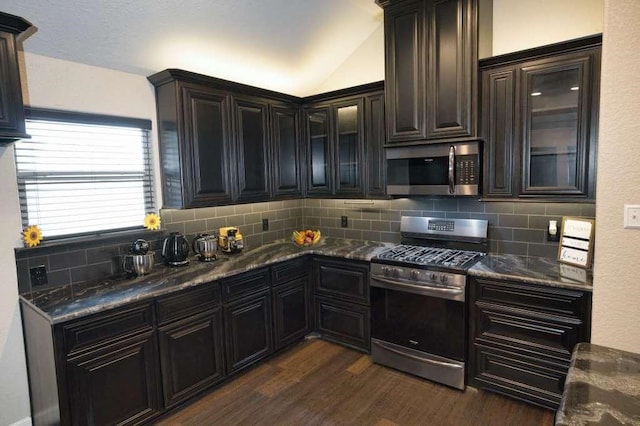 107 Brazos Ct, Richwood, TX 77531 - kitchen featuring stainless steel appliances, decorative backsplash, dark wood-style flooring, glass insert cabinets, and dark stone countertops