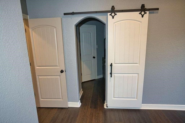 107 Brazos Ct, Richwood, TX 77531 - hall with wood finished floors, a textured wall, arched walkways, and baseboards