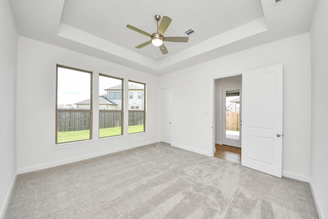 21122 Flowerhorn Dr, Cypress, TX 77433 - spare room with a tray ceiling, light colored carpet, baseboards, and a ceiling fan