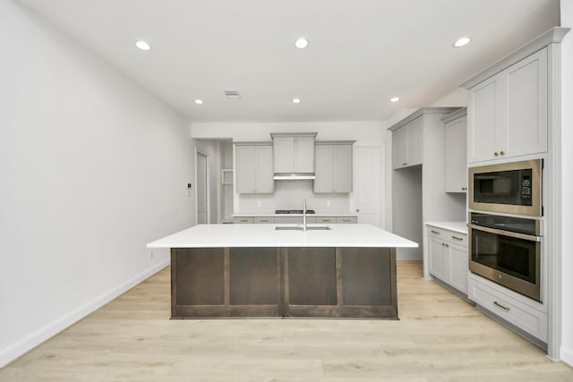 21122 Flowerhorn Dr, Cypress, TX 77433 - kitchen featuring stainless steel oven, gray cabinetry, built in microwave, an island with sink, and recessed lighting