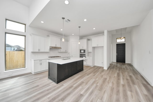 21114 Regal Terrace Dr, Cypress, TX 77433 - kitchen featuring white cabinetry, light countertops, a sink, an island with sink, and recessed lighting
