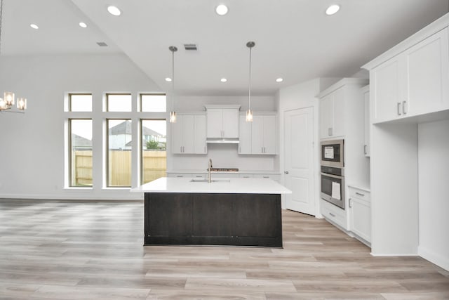 21114 Regal Terrace Dr, Cypress, TX 77433 - kitchen with white cabinets, light countertops, a center island with sink, recessed lighting, and hanging light fixtures