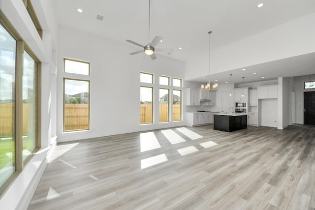 21114 Regal Terrace Dr, Cypress, TX 77433 - unfurnished living room with a chandelier, healthy amount of natural light, a high ceiling, ceiling fan, and recessed lighting