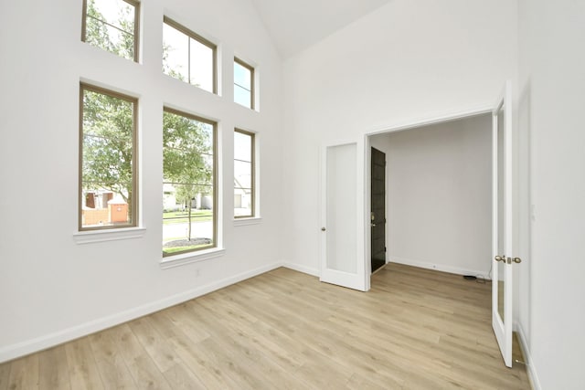 21130 Flowerhorn Dr, Cypress, TX 77433 - empty room with light wood finished floors, baseboards, and high vaulted ceiling