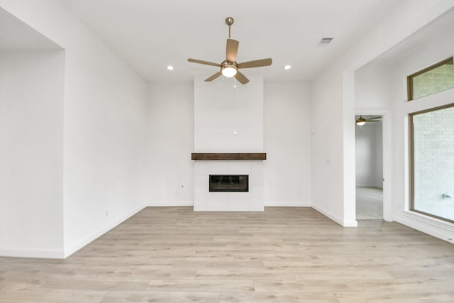 21130 Flowerhorn Dr, Cypress, TX 77433 - unfurnished living room with a ceiling fan, light wood finished floors, a tiled fireplace, and recessed lighting