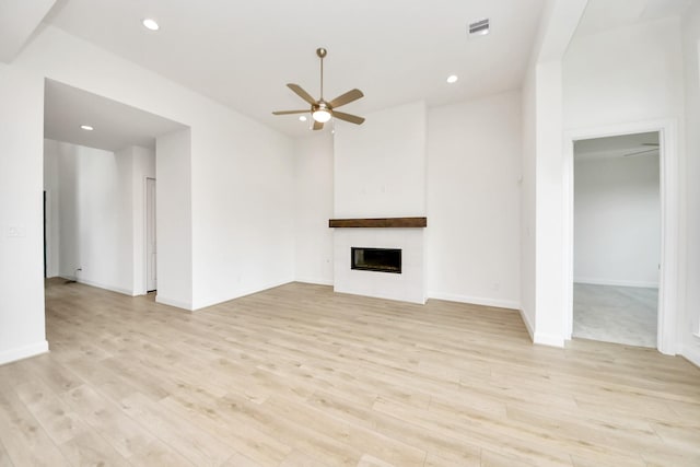 21130 Flowerhorn Dr, Cypress, TX 77433 - unfurnished living room with ceiling fan, a large fireplace, light wood finished floors, recessed lighting, and baseboards