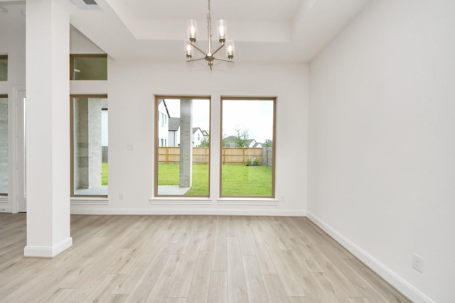 21130 Flowerhorn Dr, Cypress, TX 77433 - unfurnished dining area featuring a tray ceiling, light wood-type flooring, a chandelier, and baseboards