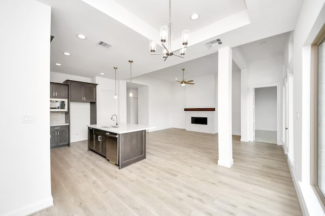 21130 Flowerhorn Dr, Cypress, TX 77433 - kitchen with a sink, dark brown cabinetry, open floor plan, a chandelier, and light countertops