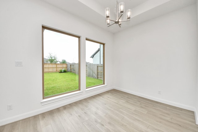 21130 Flowerhorn Dr, Cypress, TX 77433 - spare room featuring a chandelier, light wood-style floors, and baseboards