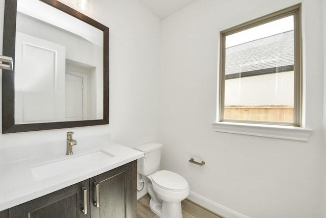 21130 Flowerhorn Dr, Cypress, TX 77433 - bathroom with baseboards, vanity, toilet, and wood finished floors