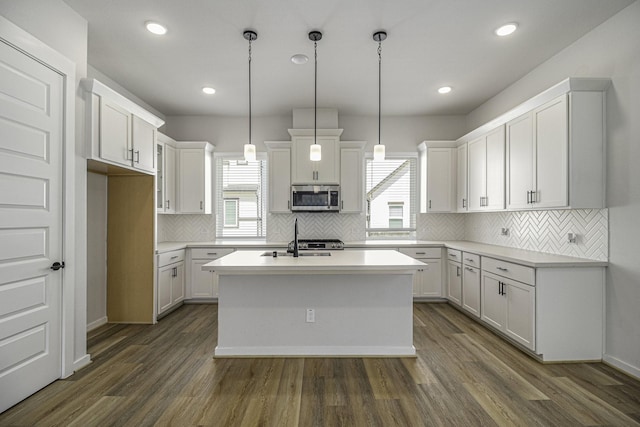 1930 Pueblo Nuevo Path, Houston, TX 77077 - kitchen with stainless steel microwave, plenty of natural light, a kitchen island with sink, dark wood-type flooring, and recessed lighting