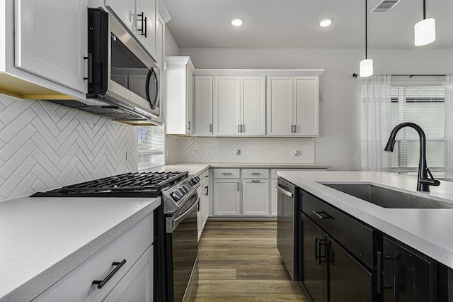 1930 Pueblo Nuevo Path, Houston, TX 77077 - kitchen featuring appliances with stainless steel finishes, a sink, light countertops, white cabinets, and decorative light fixtures