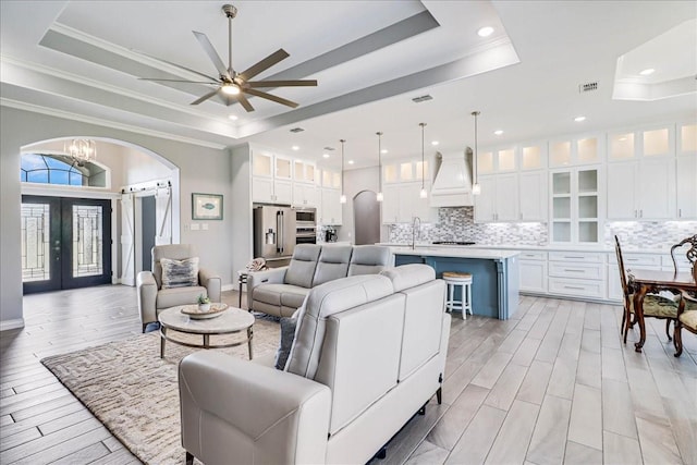8105 Denali Dr, Corpus Christi, TX 78414 - living area with a tray ceiling, ornamental molding, french doors, a ceiling fan, and arched walkways