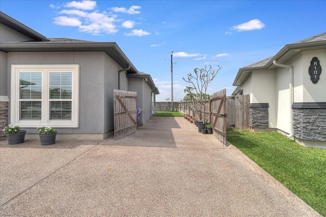 8105 Denali Dr, Corpus Christi, TX 78414 - view of side of property with stucco siding and a patio