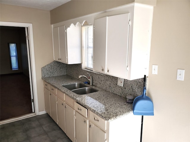 4919 Redfish Reef St, Bacliff, TX 77518 - kitchen with a sink, backsplash, baseboards, and dark tile patterned floors