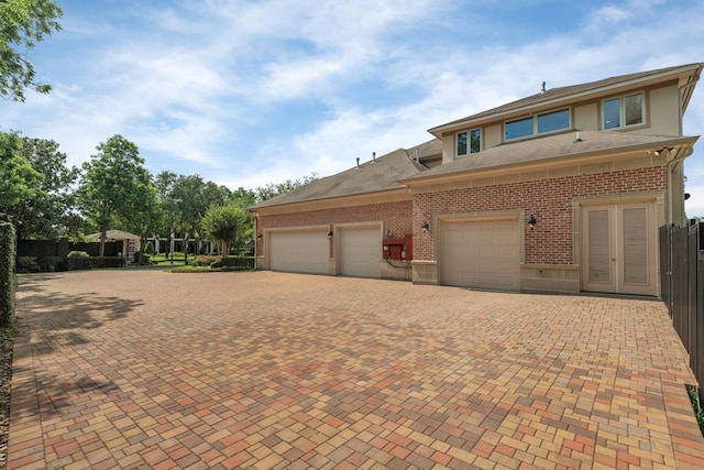 16 Grand Mnr, Sugar Land, TX 77479 - view of front of house with brick siding, decorative driveway, a garage, and a shingled roof
