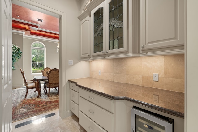 16 Grand Mnr, Sugar Land, TX 77479 - kitchen with beverage cooler, glass insert cabinets, backsplash, and dark stone countertops