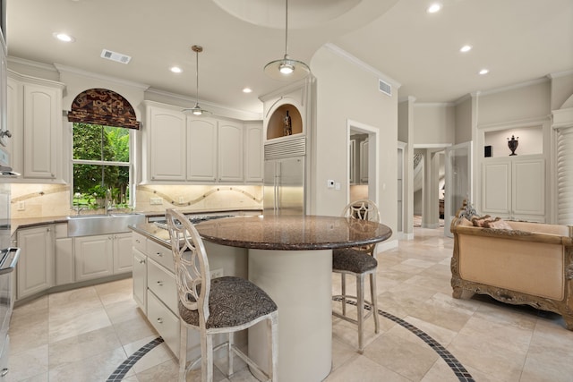 16 Grand Mnr, Sugar Land, TX 77479 - kitchen with stainless steel built in fridge, a sink, a kitchen breakfast bar, recessed lighting, and crown molding