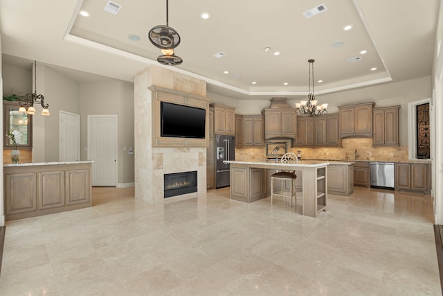 16 Grand Mnr, Sugar Land, TX 77479 - kitchen with appliances with stainless steel finishes, a raised ceiling, a breakfast bar, a sink, and tasteful backsplash