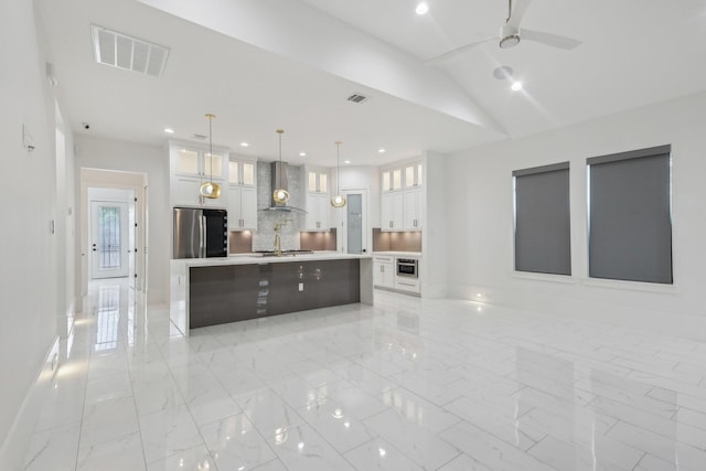 3505 Cobb St, Houston, TX 77004 - kitchen with freestanding refrigerator, wall chimney range hood, white cabinets, a spacious island, and light countertops