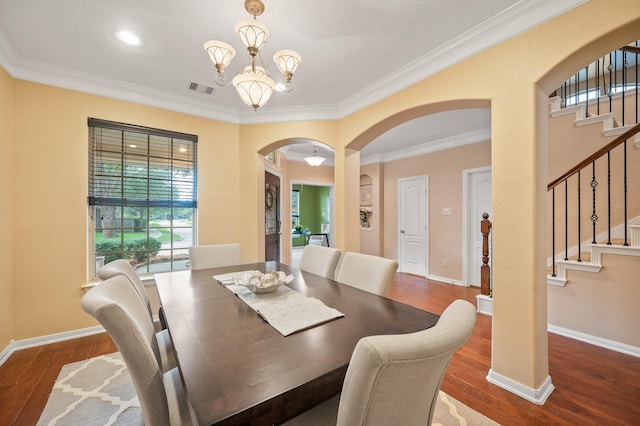 4726 Ashley Hope Dr, Katy, TX 77494 - dining space with arched walkways, stairs, wood finished floors, a chandelier, and ornamental molding