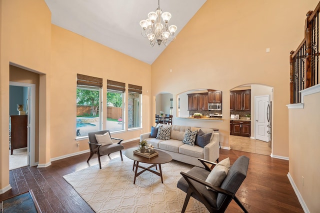 4726 Ashley Hope Dr, Katy, TX 77494 - living room featuring arched walkways, high vaulted ceiling, wood finished floors, a chandelier, and baseboards