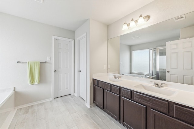 922 Steel Blue Dr, Houston, TX 77073 - full bath with double vanity, a stall shower, a bath, baseboards, and wood finished floors