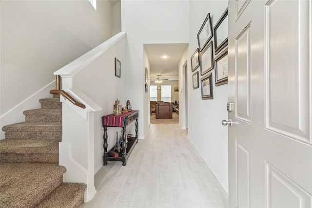 922 Steel Blue Dr, Houston, TX 77073 - hall featuring stairs, light wood-style flooring, baseboards, recessed lighting, and a high ceiling