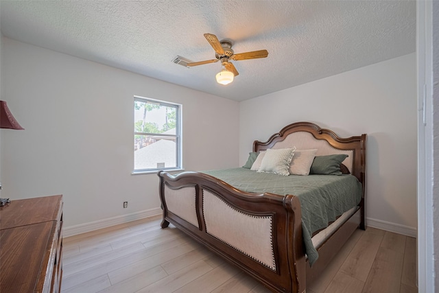 2831 Thorne Creek Ln, Houston, TX 77073 - bedroom featuring a textured ceiling, light wood-style flooring, baseboards, and a ceiling fan