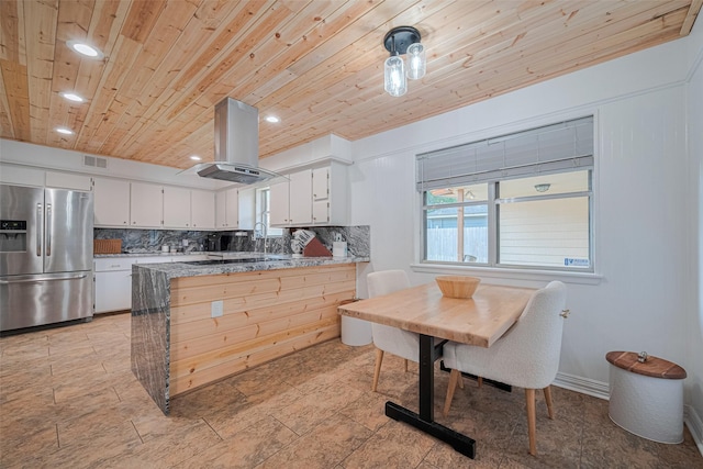 2831 Thorne Creek Ln, Houston, TX 77073 - kitchen featuring stainless steel fridge, island range hood, wood ceiling, backsplash, and a peninsula