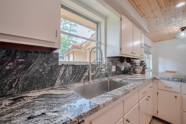 2831 Thorne Creek Ln, Houston, TX 77073 - kitchen with a sink, wooden ceiling, white cabinets, backsplash, and light stone counters