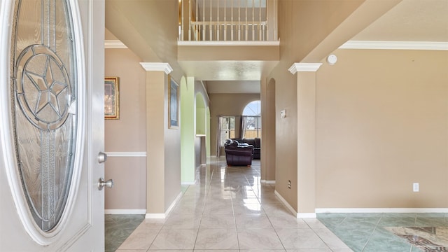 12422 Glenleigh Dr, Houston, TX 77014 - foyer with arched walkways, ornate columns, baseboards, crown molding, and a high ceiling