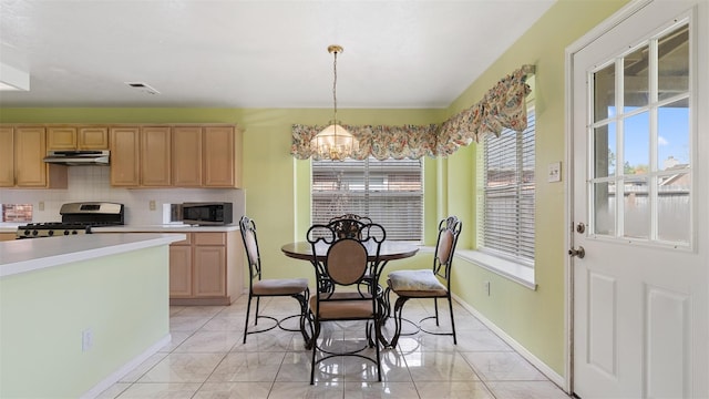 12422 Glenleigh Dr, Houston, TX 77014 - kitchen with stainless steel appliances, under cabinet range hood, a chandelier, light countertops, and tasteful backsplash